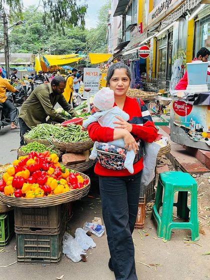 A real-life mom moment, shopping for vegetables at a local market with my baby safely snuggled in his carrier.