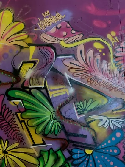 A detail shot of the nature piece, focusing on the mushroom character and the textures of the leaves and flowers.