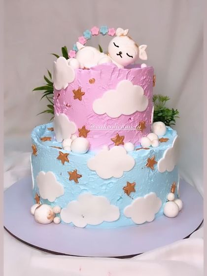 This two-tier baby shower cake is almost too cute to cut. It features a sleeping lamb on a bed of clouds and stars, in soft pink and blue whipped cream.