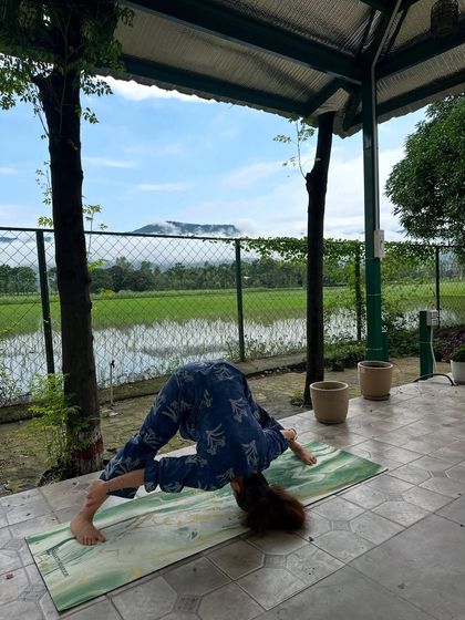 A deep forward fold in the Prasarita Padottanasana, or wide-legged forward bend. This pose is excellent for calming the mind and stretching the hamstrings and back.