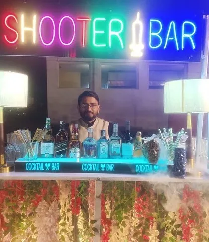 A full view of one of my shooter bar setups. It features a floral-decorated front, a bright neon sign, and a well-stocked bar ready for a fun night.