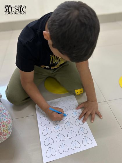 Another student engaged in our rhythm dictation exercise. We ensure each child gets the opportunity to practice and build their confidence with fundamental musical concepts.