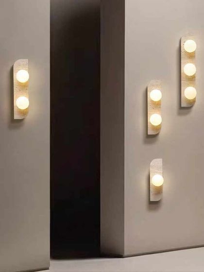A series of minimalist marble wall sconces. These fixtures can be arranged in various patterns to create a custom look for a hallway or feature wall.