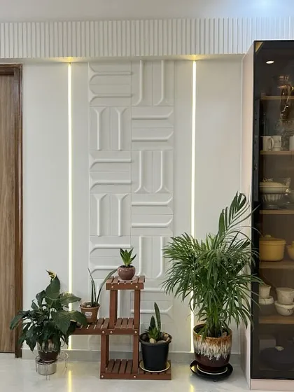 Detail of the entryway, where a stylish door, curated plants, and an elegant glass crockery unit come together to create a warm welcome.