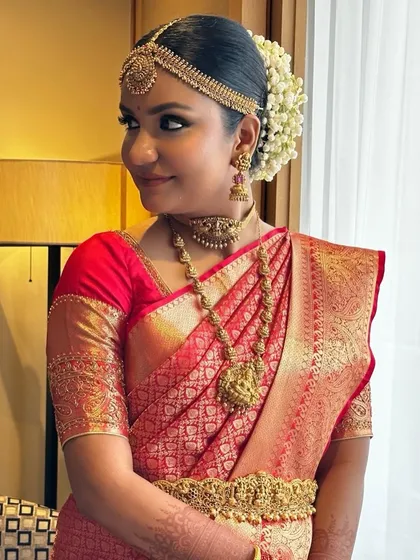 Crafting a traditional South Indian bridal look for Deepika was a joy. We focused on classic elements like the temple jewelry, a neat floral bun, and makeup that highlighted her features with a timeless, golden radiance.