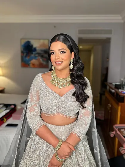 Shreya shines brightest in ivory for her reception. This look is all about sophisticated glam with a focus on flawless skin and defined eyes.