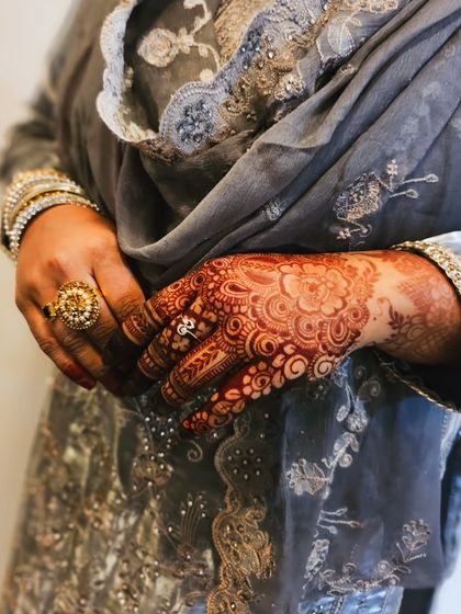 The deep color of the henna stain against a lovely grey outfit.