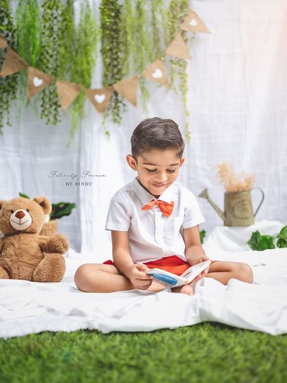 A quiet moment of reading during a fourth birthday photoshoot. Outdoor sessions allow for natural, lifestyle portraits that tell a story.