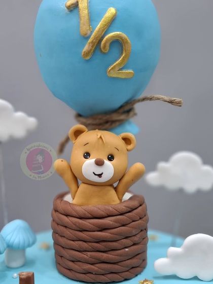 A close-up of the cute teddy bear in the hot air balloon, a signature detail of our popular half-birthday cakes.