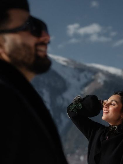 A sun-kissed moment of happiness in the snowy mountains. The natural light and joyful expression make this a beautiful, candid portrait that feels warm and genuine.