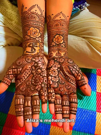 A non-figurative henna art design with floral motifs and the couple's initials.
