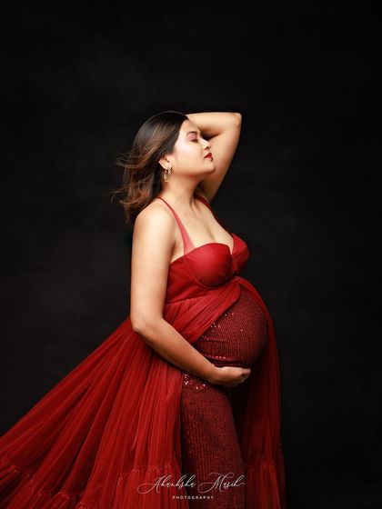 A side profile in a stunning red sequin and tulle gown, capturing a moment of quiet confidence and anticipation.