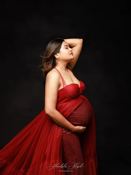 A side profile in a stunning red sequin and tulle gown, capturing a moment of quiet confidence and anticipation.