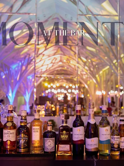 A lineup of premium spirits on our bar, beautifully lit to create an inviting "Moments at the Bar" scene. This image showcases the quality and variety of liquors we provide for our events.