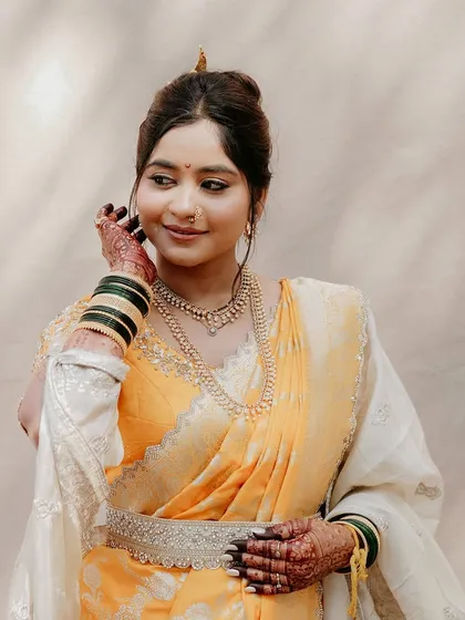 A close-up portrait highlighting the delicate details of her makeup, the traditional jewelry, and her radiant skin.