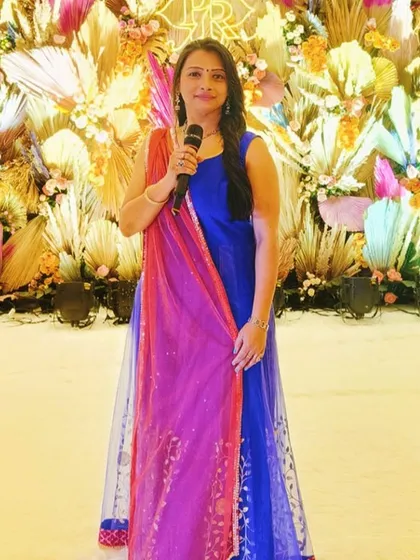 As your emcee, I am the voice of your celebration. This moment, captured at an engagement ceremony at the Garware Club, shows me in my element, microphone in hand, ready to guide the event and keep the energy high.