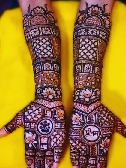This design combines spiritual elements like the Ganesha motif and the Om symbol with the groom's name (Pritam) for a truly personalized and auspicious bridal look.