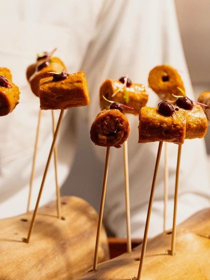 Skewered kebabs with an olive topping, presented creatively on a wooden block. An easy-to-eat and flavorful appetizer.