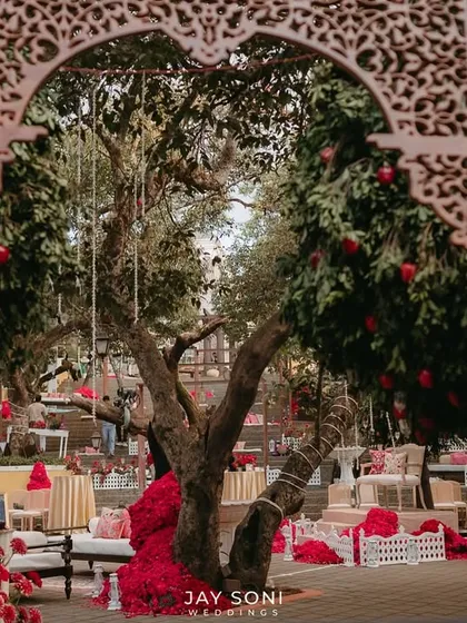 Looking through the intricately carved wooden arch, this view frames the beautiful Mehfil-e-Mehendi setup, creating a sense of discovery and anticipation.