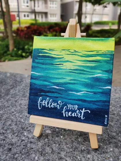 My mini canvas paintings are perfect for adding a little inspiration to your desk or shelf. This piece features a simple ocean scene with the hand-lettered quote 'Follow your heart', painted with acrylics.