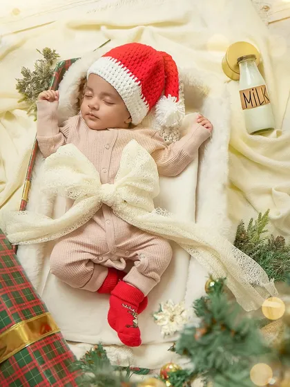The perfect little Christmas present, tied with a bow. This creative newborn shot is a beautiful and artistic way to celebrate a baby's first holiday season.