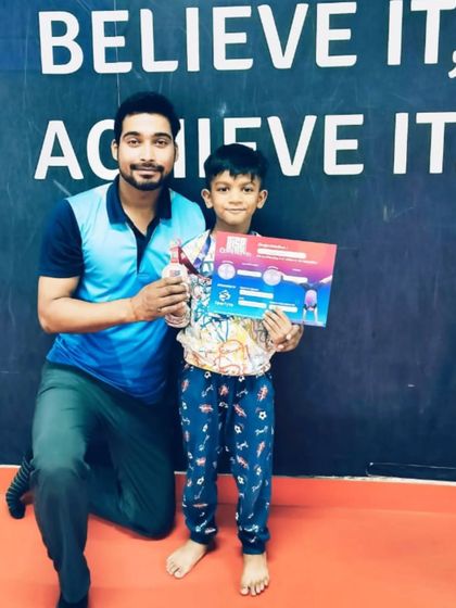 A proud student with his certificate and medal, celebrating his hard-earned victory.