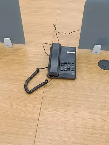 A basic telephone handset placed on an office desk, connected to the central EPABX system for internal and external calls.