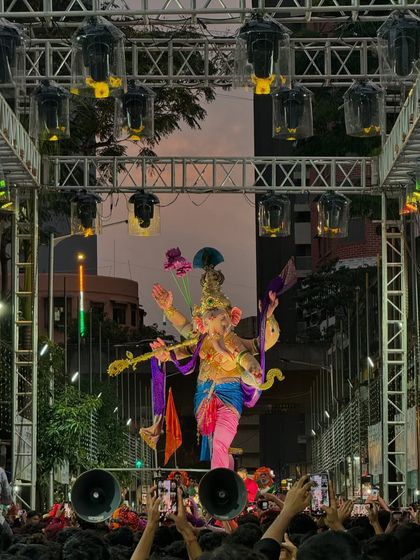 As dusk falls, the lighting rig comes to life. This image captures the moment the lights are turned on for the Kalachowkicha Mahaganpati Aagman, with the idol perfectly framed by the truss and ready for its grand entrance.