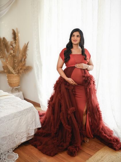 The dramatic red gown with a long train makes a powerful statement. This full length portrait by the window is both elegant and glamorous.