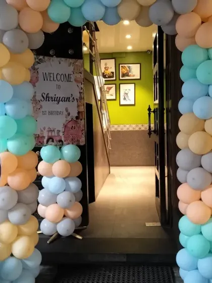The entrance to the farm-themed party, featuring a pastel balloon arch and cute elephant and zebra cutouts to greet the guests.