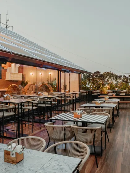 The outdoor seating area offers a more casual, open-air experience. I used a mix of woven chairs and striped tabletops to create a relaxed, bistro-like feel, perfect for enjoying the Bangalore weather.