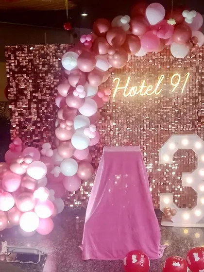 We also partner with venues for their special occasions, like this 3rd-anniversary decor for a hotel in Gurgaon. The rose gold theme includes a sequin wall, a balloon garland, and a '3' marquee number.