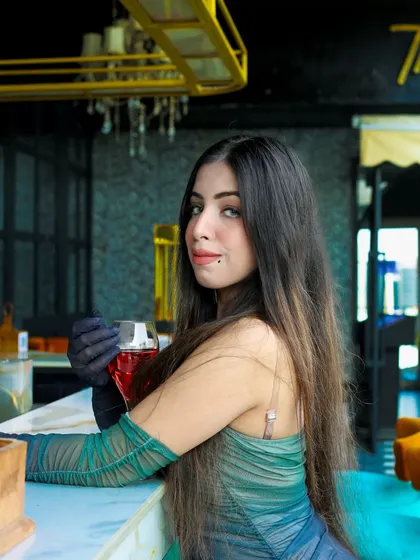 A sophisticated portrait at a bar. The model holds a drink, adding to the chic, evening-out atmosphere of the shoot. The lighting and setting are perfect for capturing a glamorous look.