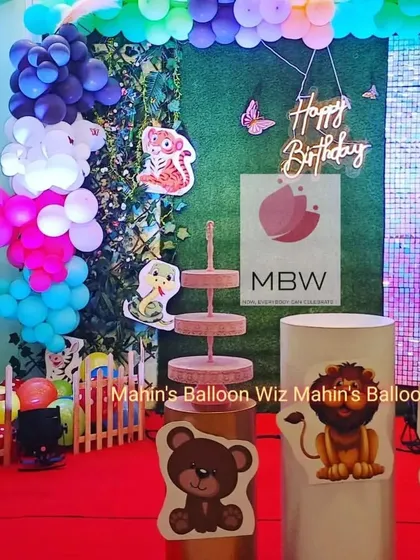 A close-up of the woodland animal theme, showing the detailed cutouts of a bear, lion, and elephant on the pedestals, along with a multi-tiered cake stand.