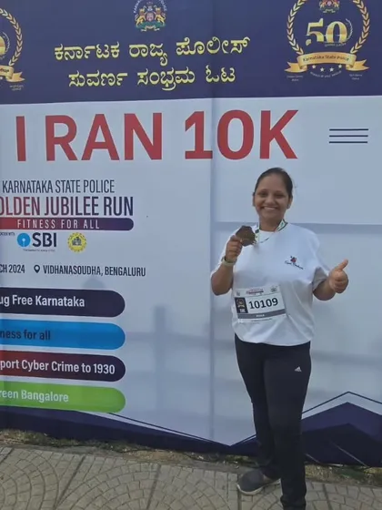 A team member proudly posing with her medal after the Karnataka State Police Golden Jubilee 10K Run.