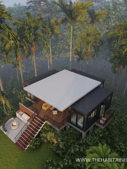 A render of the 3BHK container home at dusk, nestled in a foggy, forested environment.