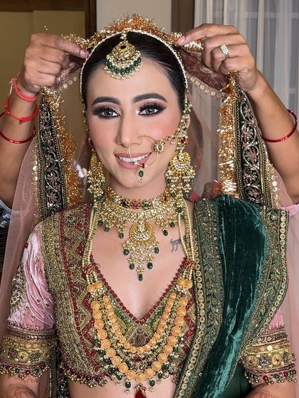 A touching moment as the dupatta is placed on her head. The makeup remains flawless and radiant.