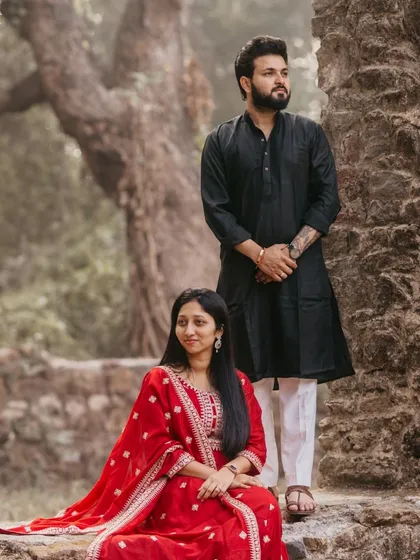 A powerful pose from a pre-wedding shoot in a rustic, historic setting. The contrast between their elegant ethnic wear and the old stone walls creates a striking image.