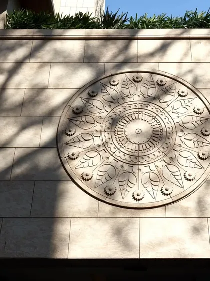 A close-up of a custom-carved stone medallion on the facade of our Pali Hill project. This intricate detail, capturing the play of sunlight and shadow, adds a touch of traditional artistry to the modern building.
