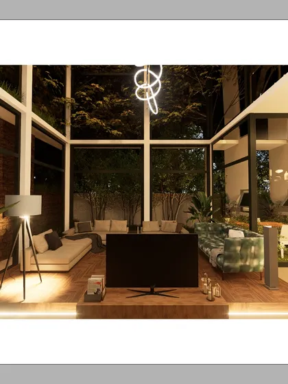 The living area of the Courtyard Glasshouse at dusk. The double-height glass walls dissolve the boundary between inside and out, while our carefully planned ambient and feature lighting creates a warm, inviting atmosphere for the evening.
