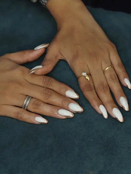 A full view of the elegant white and gold chrome drip nails.