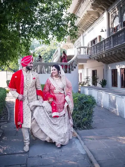 A fairytale-like shot of the couple walking through the grounds of a heritage property, perfect for a destination wedding album.