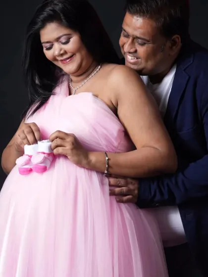 A fun and loving pose for an expecting couple. Using props like baby shoes adds a playful and personal element to your couple's maternity photoshoot.