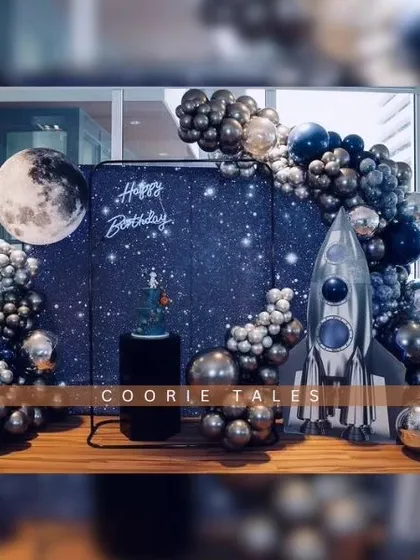 Three, two, one, blast off! We create out-of-this-world experiences like this space-themed birthday party, complete with a starry backdrop, a giant moon, a silver rocket ship, and metallic balloon details for your little astronaut.