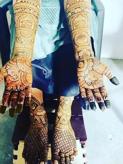 A complete bridal set with matching traditional designs on both hands and feet, shown here after the henna has been applied.