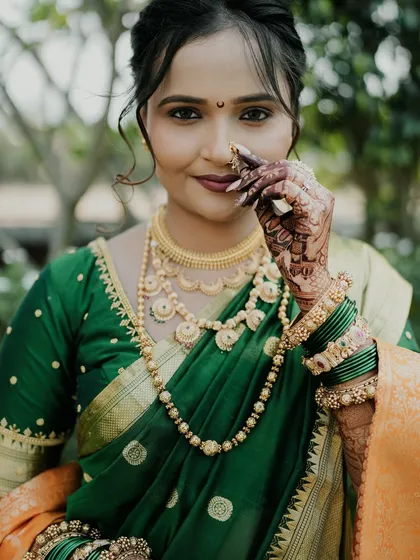 A close-up of the bride's happy face, with her mehendi-adorned hand adding to the picture.