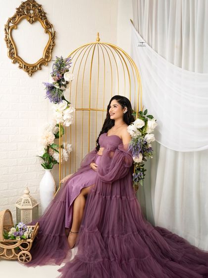 A dreamy, upward glance captures the hope and excitement of pregnancy. The purple tulle of the gown drapes beautifully, adding to the romantic feel of the portrait.