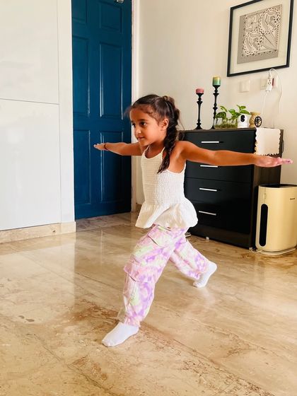 Holding a strong warrior pose. Yoga asanas like this are integrated into our classes to build balance, focus, and physical strength.