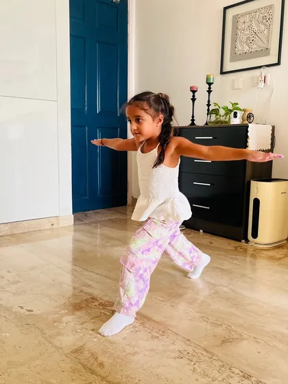Holding a strong warrior pose. Yoga asanas like this are integrated into our classes to build balance, focus, and physical strength.
