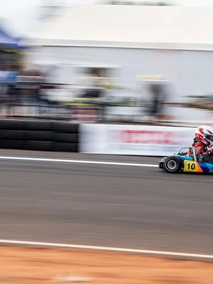 A Micro driver at speed, the background blurred to emphasize the velocity of the kart.